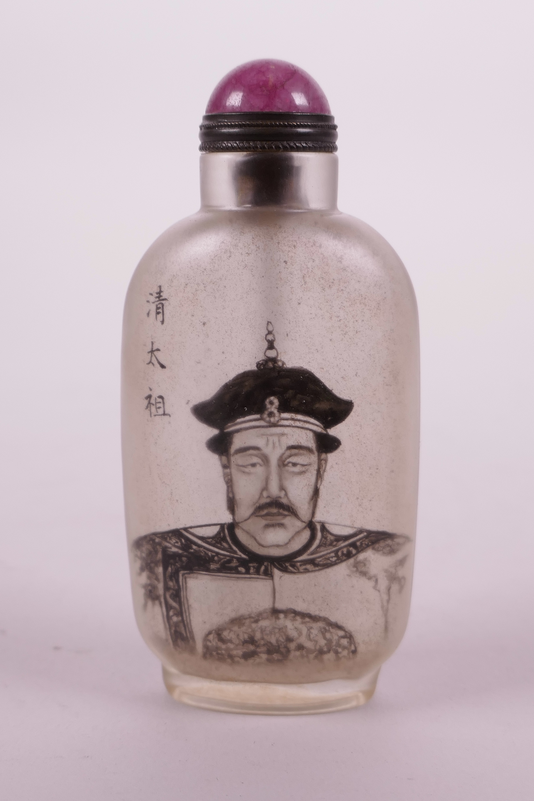 A Chinese reverse painted glass snuff bottle decorated with a monochrome portrait of a Chinese