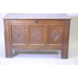 An C18th French oak coffer, with triple panel front and carved decoration, raised on stile supports,