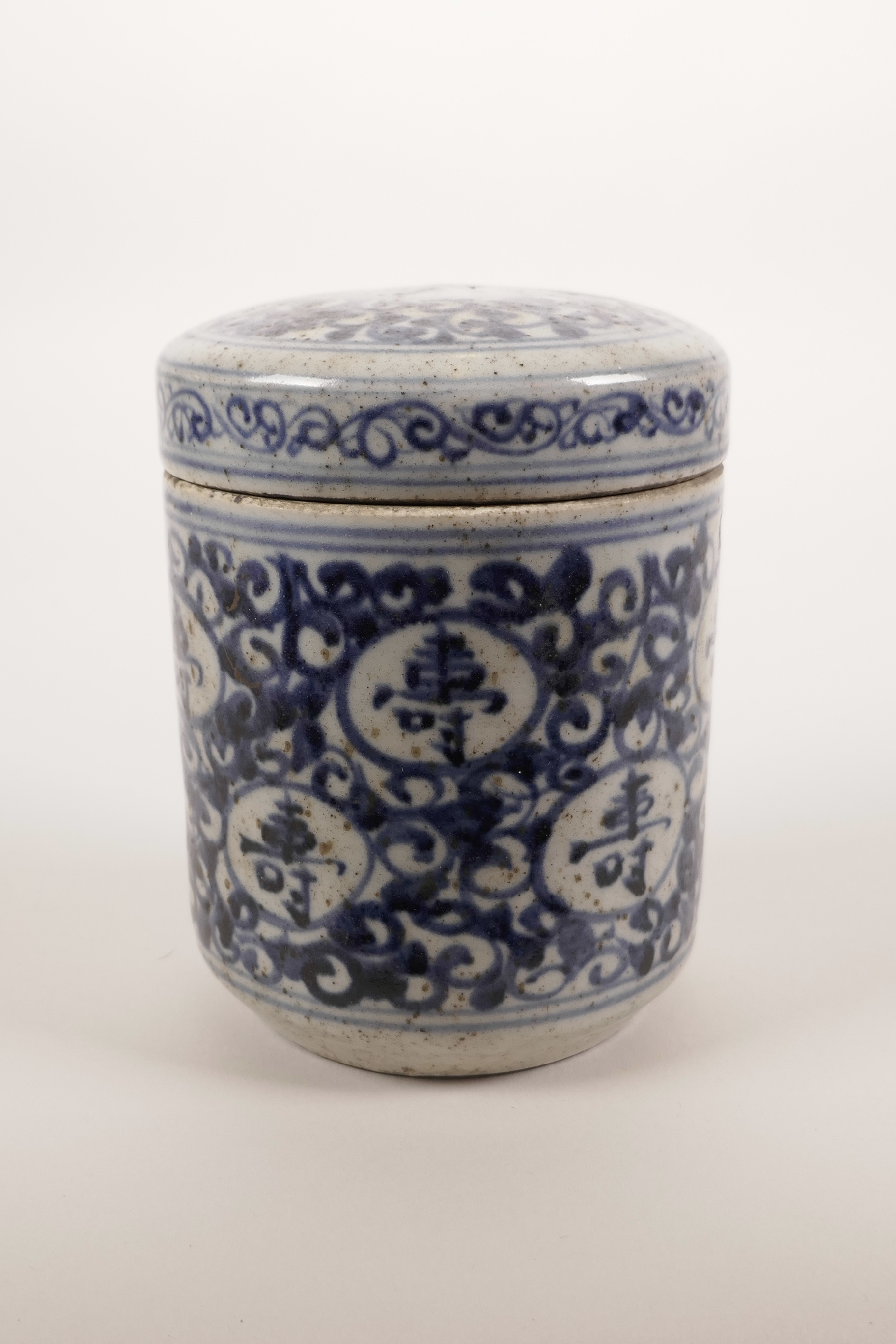 A Chinese blue and white pottery trinket pot and cover with all over auspicious character