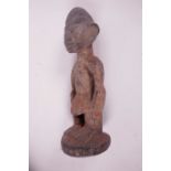 A West African carved wood tribal figure, 10" high