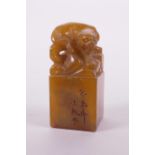 A Chinese carved amber soapstone seal with carved tiger knop, 3½" high