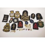 A collection of military cloth and metal badges and buttons together with a collection of early