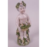 A small hard-paste porcelain figurine of a child with a basket of flowers, applied floral