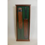 A pair of antique cricket bats in an oak display case, 15" x 39"