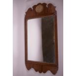 A Georgian style walnut framed wall mirror, the top carved with a shell roundel, 28" x 15"