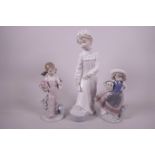 A Nao figurine of a girl in her nightclothes, 11" high, and two Lladro figurines of children with