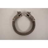 A Chinese silvered metal rope twist bangle with dragon head decoration to ends, 3½" diameter
