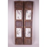 A pair of Chinese hardwood panels set with four polychrome enamelled porcelain panels depicting