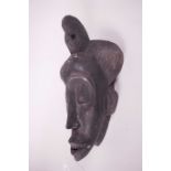 A West African carved wood tribal mask, 13" high