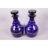 A pair of Bristol blue glass mallet shaped port and sherry decanters with enamelled with gilt