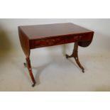 A mahogany sofa table with yew wood crossbanding on end pedestal supports and brass cap castors, 20"