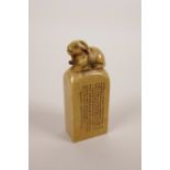 A Chinese soapstone seal with a carved knop in the form of a goat and character inscription to side,