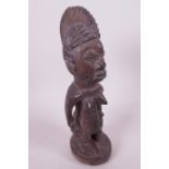 A West African carved hardwood figure, 10" high