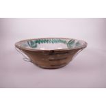 A large Continental terracotta spongeware bowl with green floral decoration, A/F pinned, 15½"