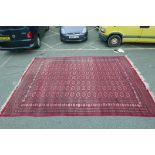 A large Persian red ground Bokhara carpet, 172" x 122"