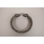 A Chinese silvered metal rope twist bangle with twin dragon head decoration to ends, 3" diameter