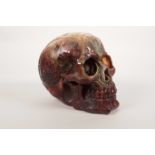 An amber resin human skull with carved esoteric decoration, 5½" high