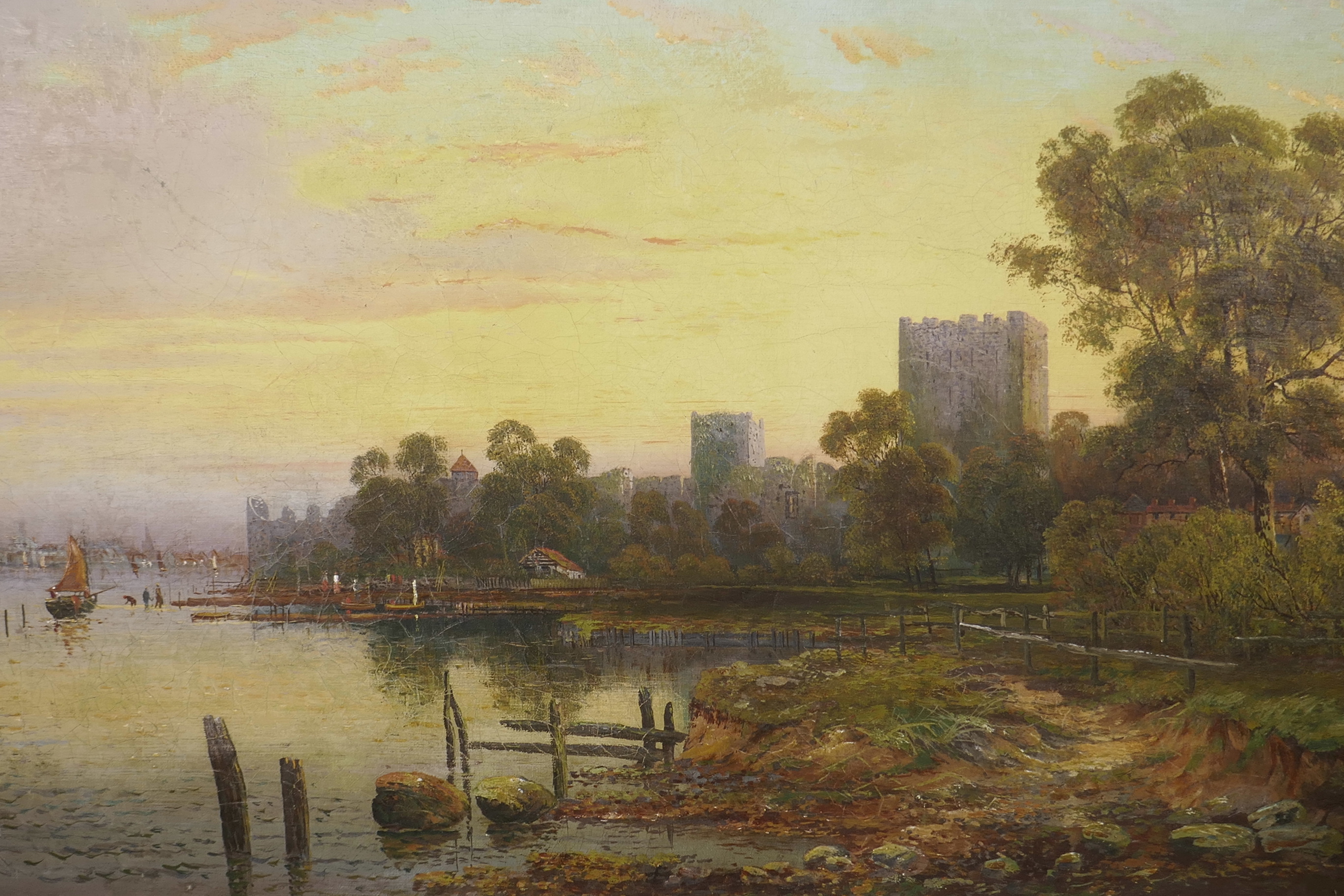 An oil on canvas, extensive river landscape at sunset with distant figures and boats, signed