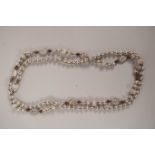 An Oriental moulded white glass beaded necklace with feature beads decorated with faces and