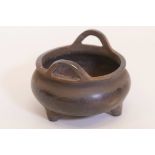 A Chinese bronze censer with phoenix eye handles, raised on tripod supports, impressed mark to base,