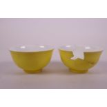 A pair of Chinese yellow ground porcelain tea bowls with white enamel dragon decoration to interior,