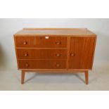 A mid C20th teak side cabinet with single cupboard and fall front drawer over two drawers,