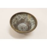 A Chinese miniature bronze bowl with raised decoration and mark to base, 2" diameter