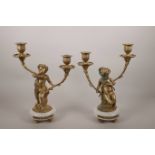 A pair of ormolu two branch candlesticks in the form of putti, on marble bases, 12" high