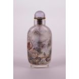 A Chinese reverse painted glass snuff bottle decorated with scenes of figures in a landscape and