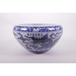 A Chinese blue and white pottery bowl with a rolled rim decorated with a dragon and phoenix in