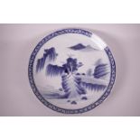 A large Chinese blue and white porcelain charger decorated with a mountain landscape, 14½" diameter