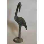 A weathered bronze figure of a heron, 35" high, A/F loss to beak