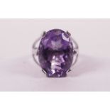 A silver lady's dress ring set with a large oval cut amethyst, approximate size 'P/Q'