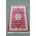 A red ground Kashmir carpet with a Shabaz medallion design, 60" x 90"