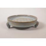 A Chinese duck-egg blue glazed shallow dish raised on tripod supports, with engraved and gilt