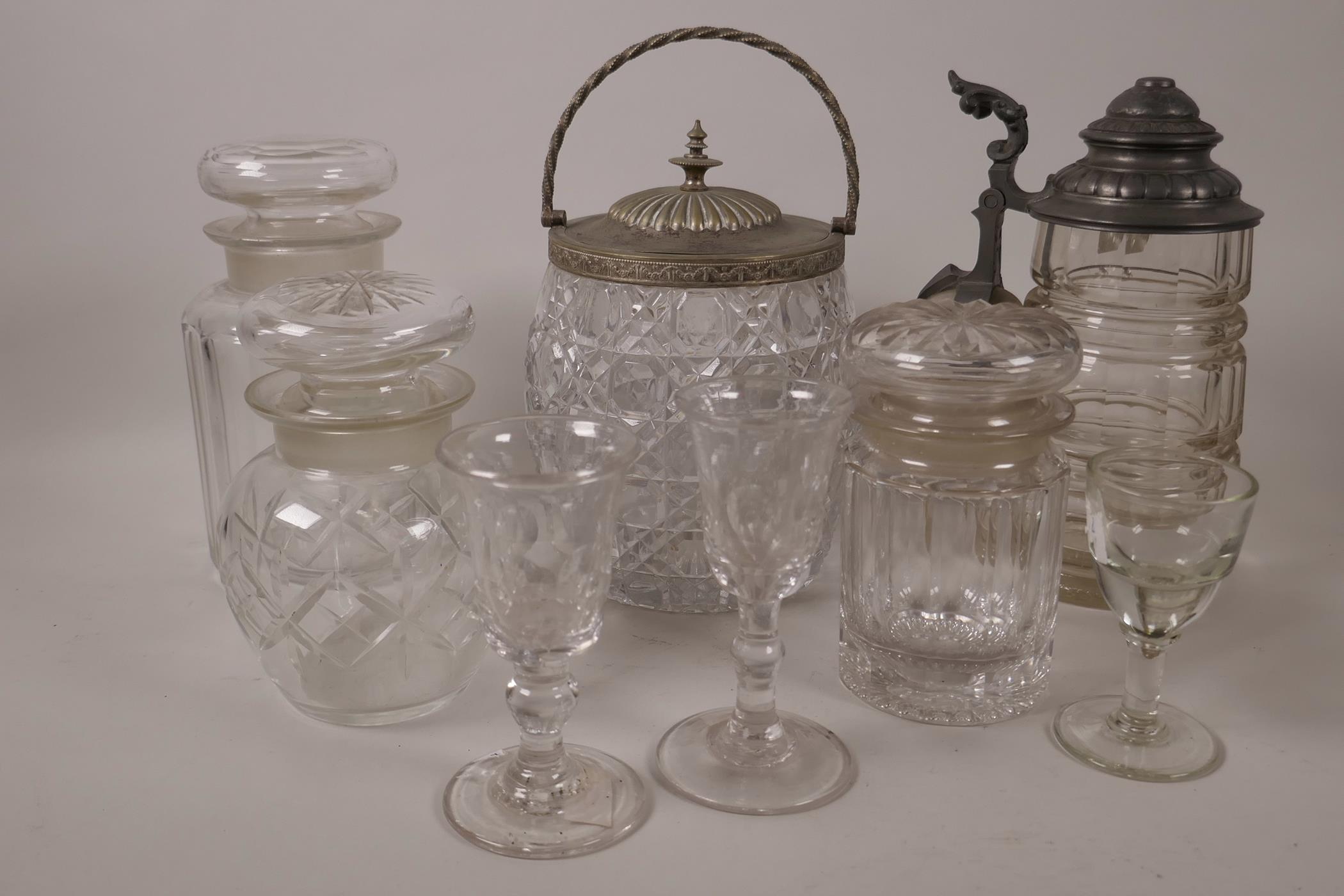 A glass biscuit barrel with silver plated lid, 7" high, together with a pewter lidded glass stein,