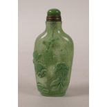 A Chinese green glass snuff bottle with carved bird, carp and flower decoration, 3½" high