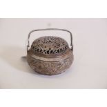 An Oriental white metal censer with pierced cover and raised decoration of bamboo and cherry