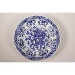 A Chinese blue and white pottery charger with a lobed rim, decorated with a dragon chasing the