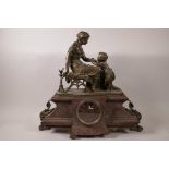 A French bronze and rouge marble mantel clock surmounted by a figurine of a lady with a small child,