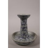 A Chinese blue and white pottery candlestick with scrolling decoration, 6" high