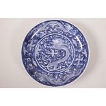 A Chinese blue and white porcelain dish decorated with a dragon chasing the flaming pearl, 6