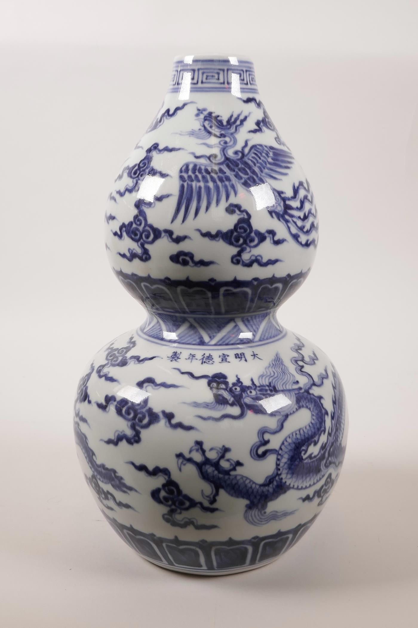 A Chinese double gourd pottery vase decorated with a dragon and phoenix in flight, 6 character