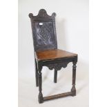 An antique oak side chair, with carved panel back and shaped apron