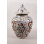 A Chinese wucai pottery jar and cover with decorative panels depicting dragons and cranes, 6