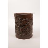 A Chinese bamboo brush pot with carved lotus pond decoration, character inscription verso, 7" high