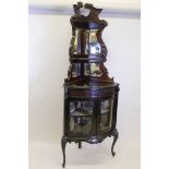 A Victorian mahogany bowfronted corner display cabinet, the upper section with mirror backed