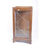 A walnut display cabinet with astragal glazed door, raised on bracket supports, 24" x 13" x 45"