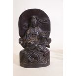 A carved hardwood figure of Quan Yin, seated upon the crest of waves, 22" high