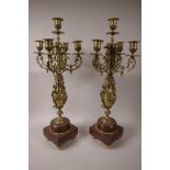 A pair of ornate brass five light table candelabra on rouge marble bases, 23" high